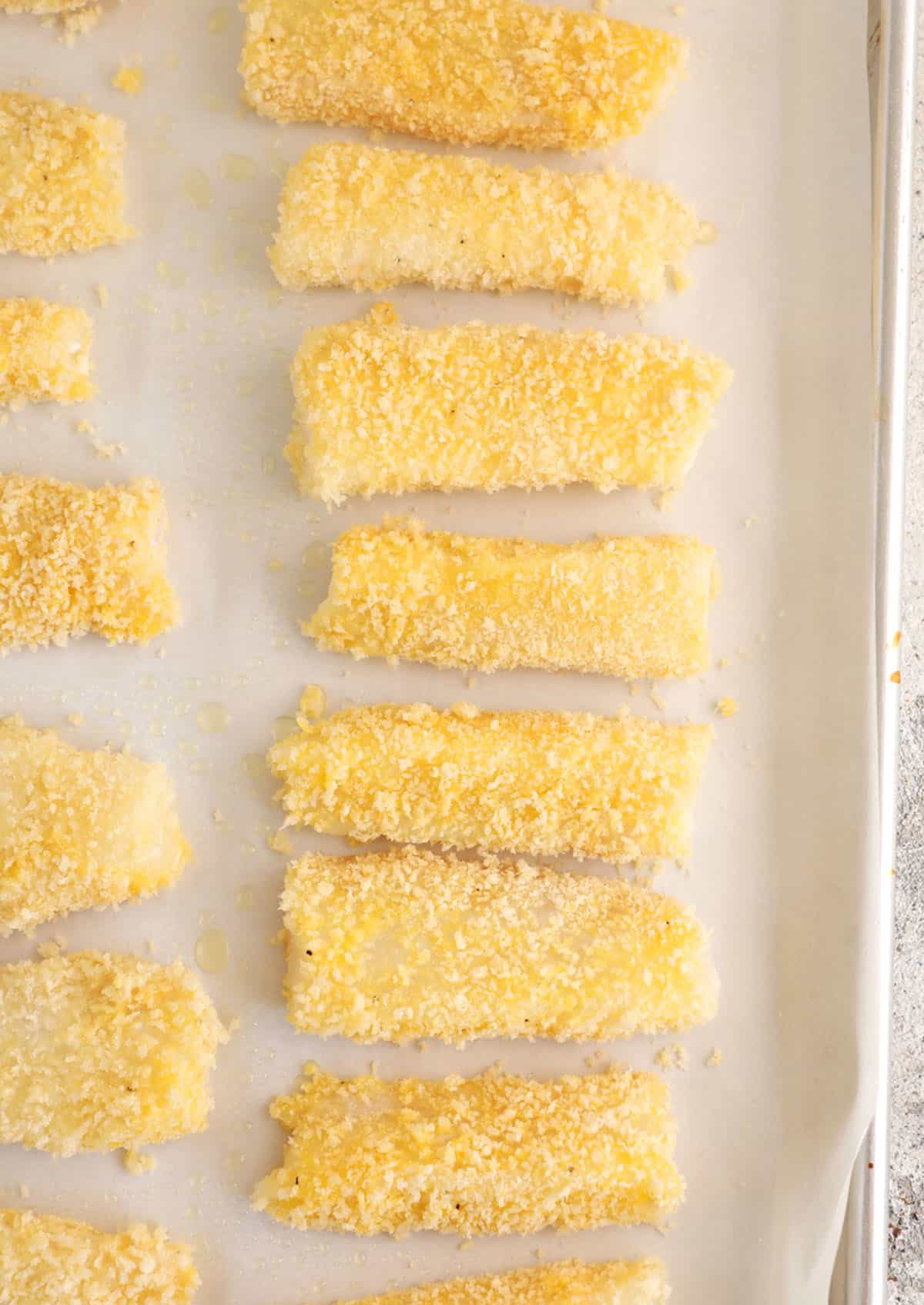 Breaded fish sticks on baking sheet before baking