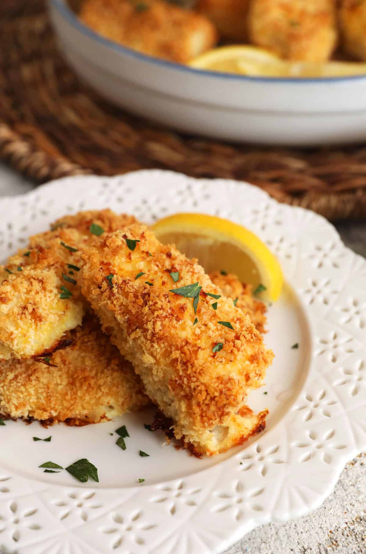 Fish sticks on plate with lemon wedges