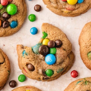 Overhead view of chocolate chip M&M cookies, with one in center bitten