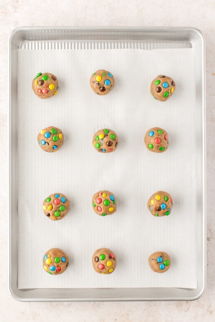 Overhead view of chocolate chip M&M cookies on baking sheet before baking