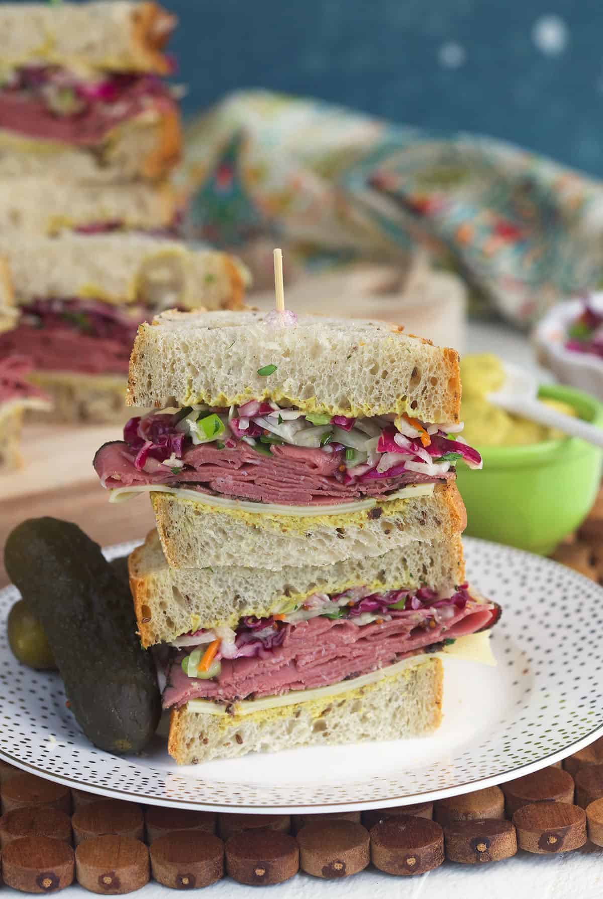 Two pastrami sandwich halves stacked on plate