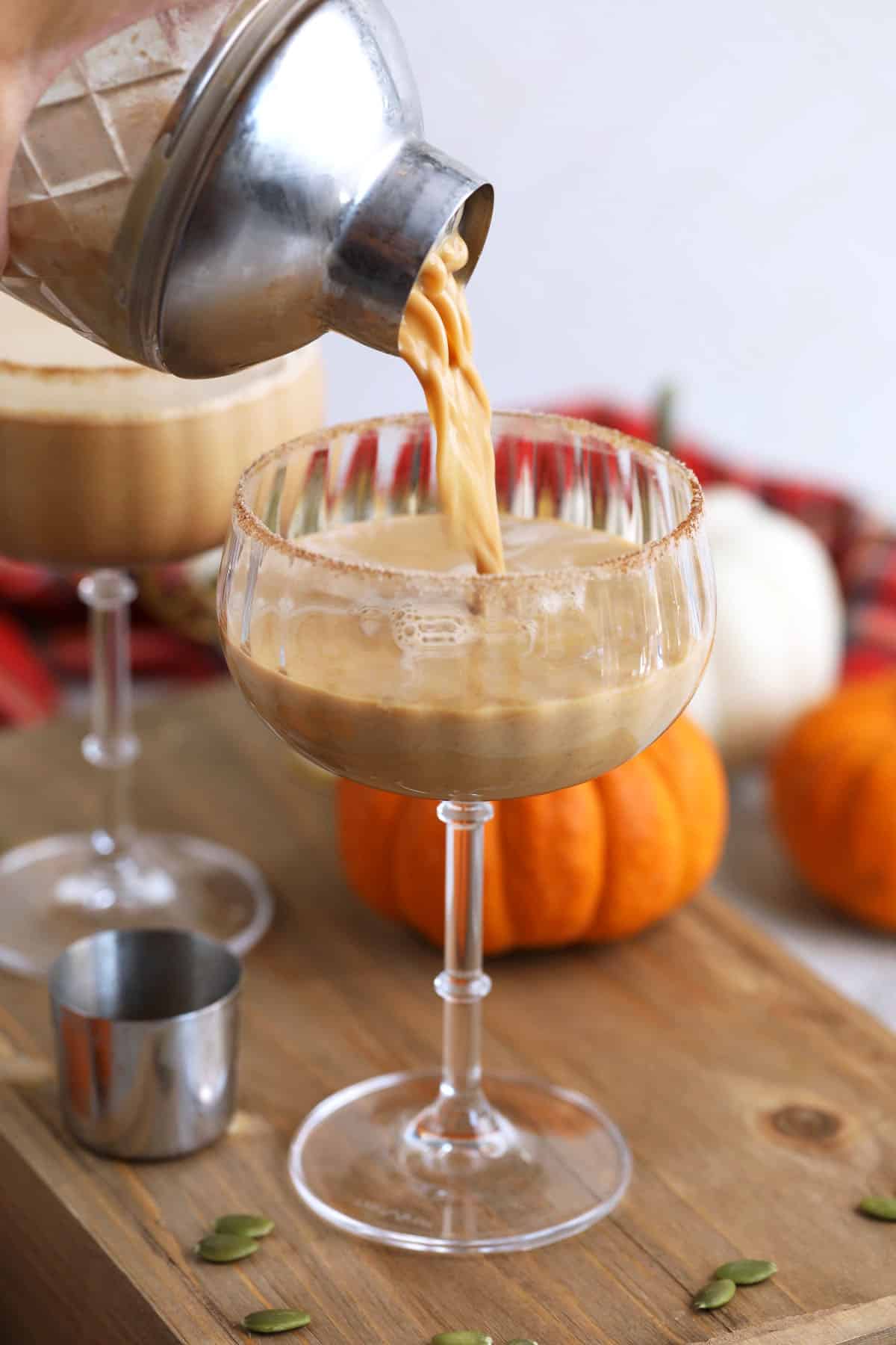 Pouring pumpkin spice latte martini into glass