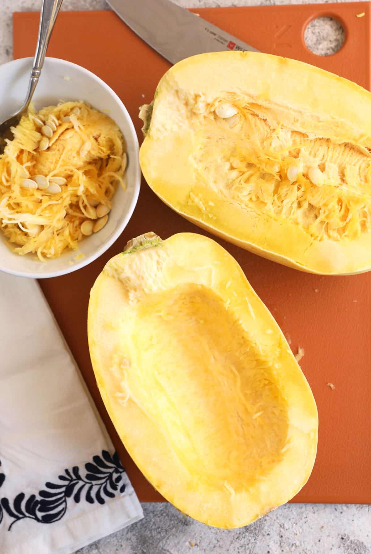 Halved spaghetti squash on cutting board