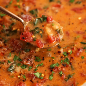 Spoonful of Tuscan white bean soup held over bowl