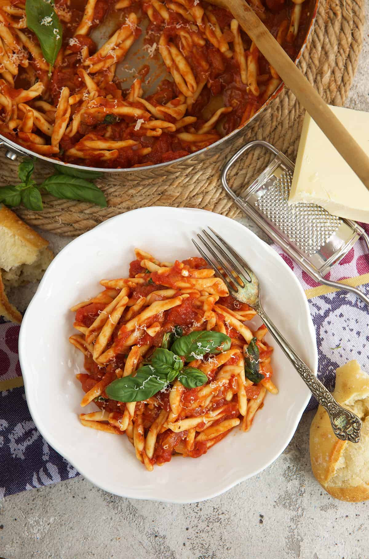 Spicy arrabbiata sauce with pasta in bowl and skillet