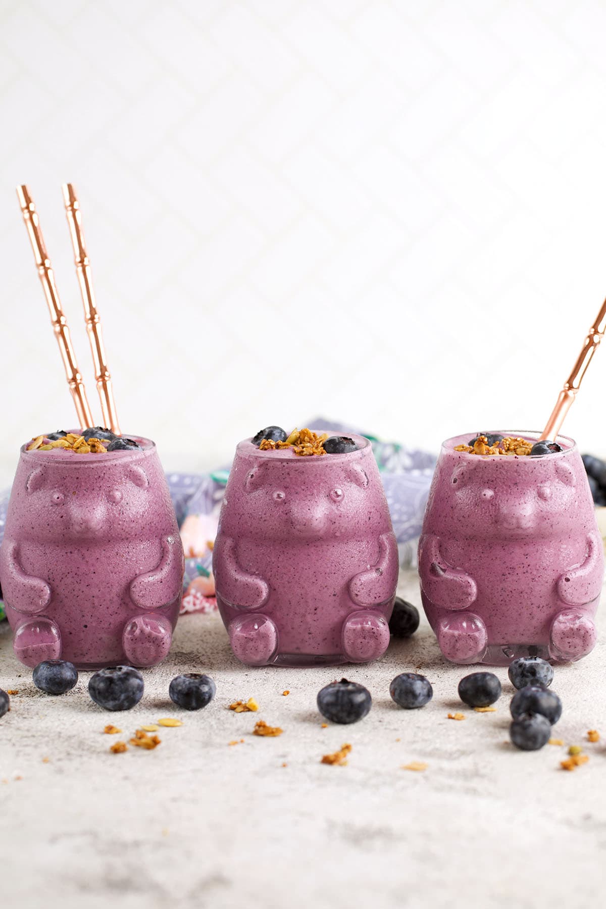 3 bear shaped glasses filled with blueberry smoothies