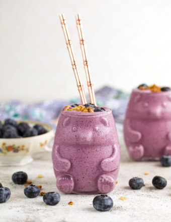 Blueberry smoothie in bear-shaped glass with glass straws