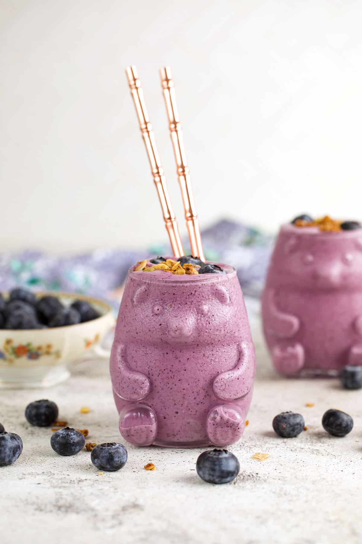 Blueberry smoothie in bear-shaped glass with glass straws