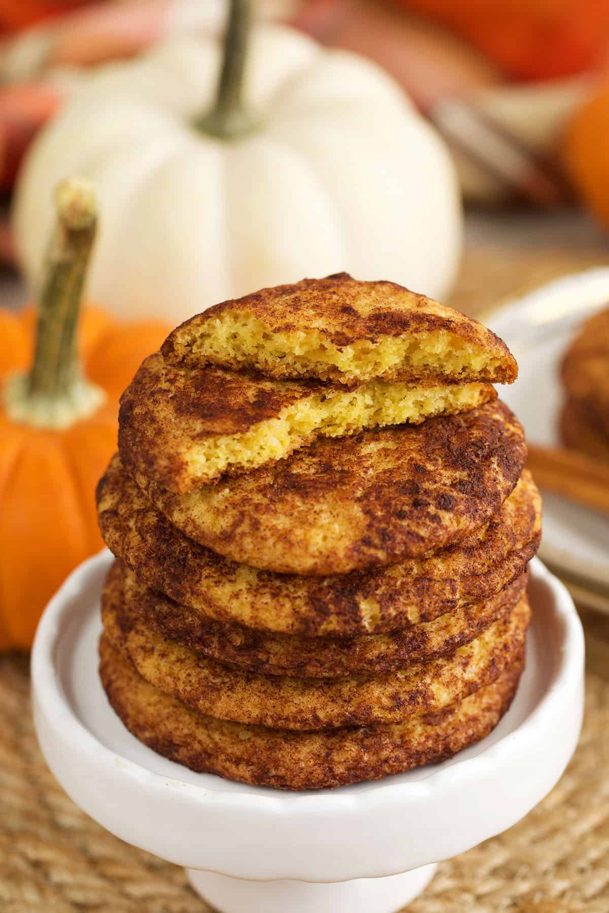 Stack of pumpkin snickerdoodles, with one broken in half to show interior