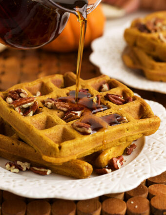 Pouring syrup onto pumpkin waffles