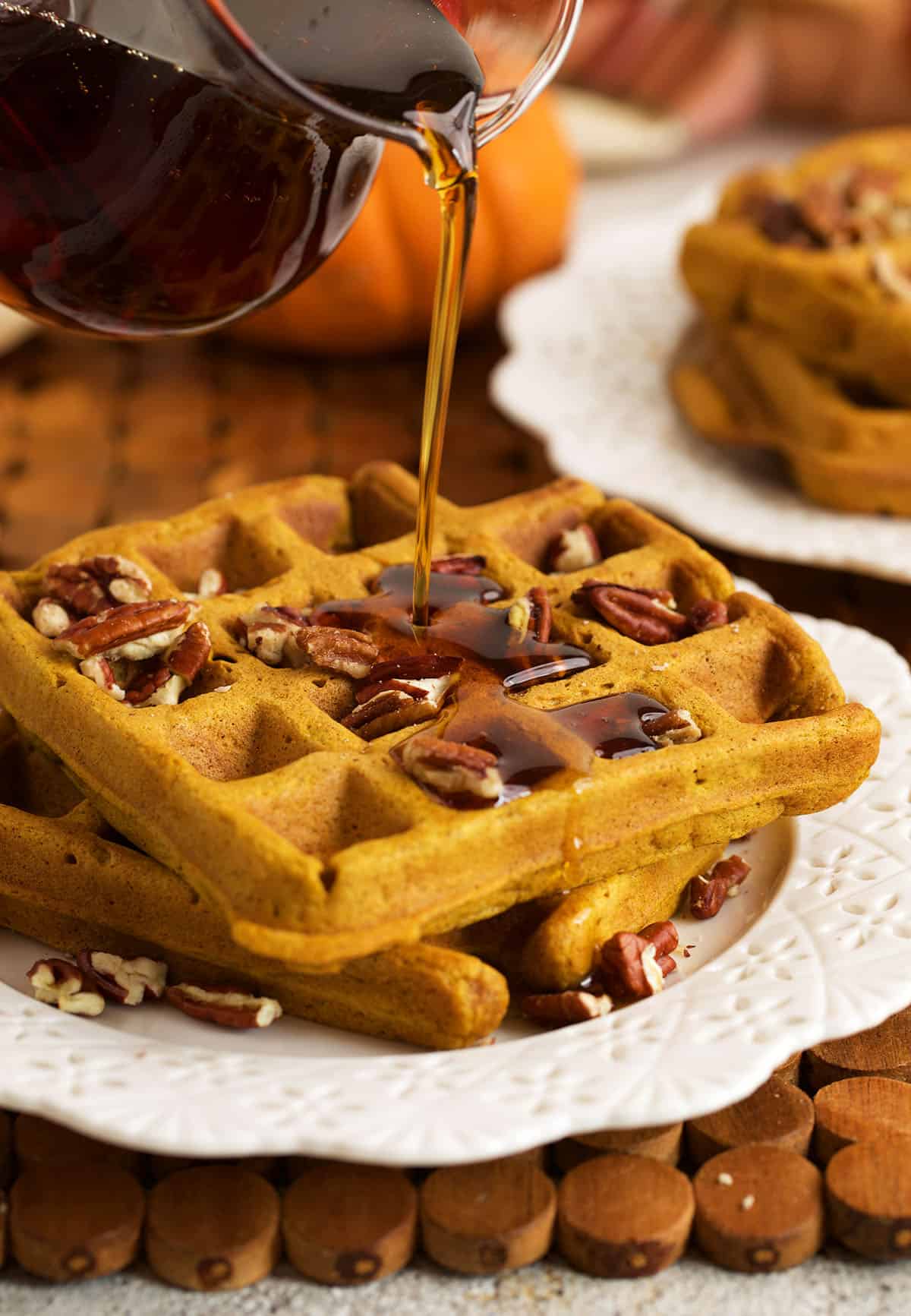 Pouring syrup onto pumpkin waffles