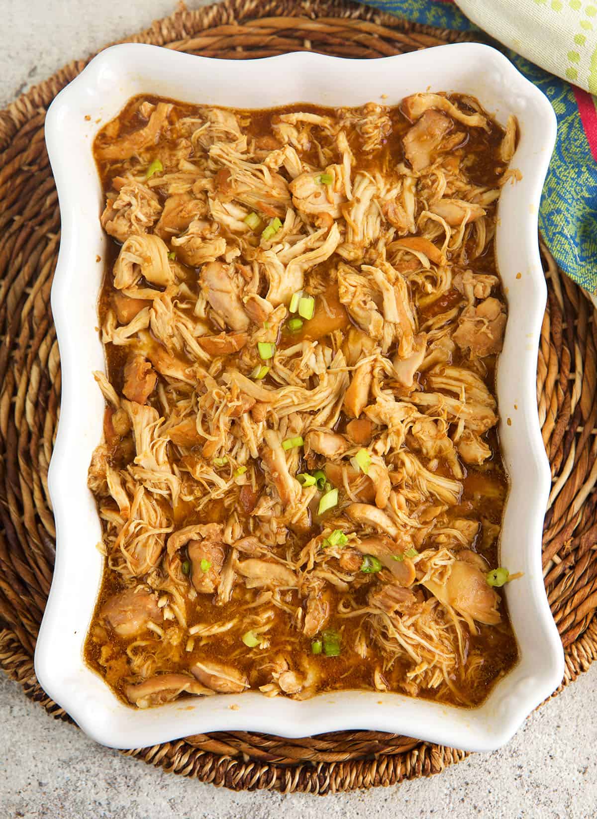 Shredded crockpot teriyaki chicken in serving dish