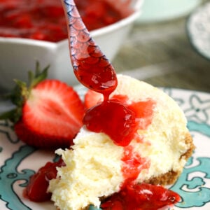 Drizzling strawberry compote over cheesecake slice