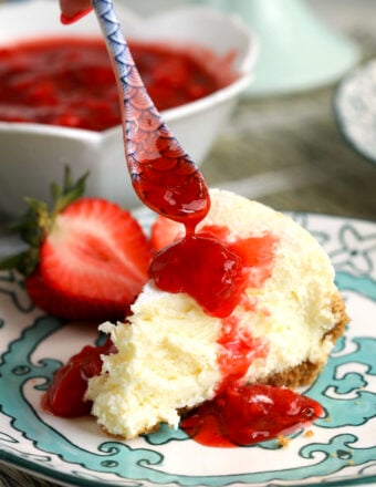 Drizzling strawberry compote over cheesecake slice