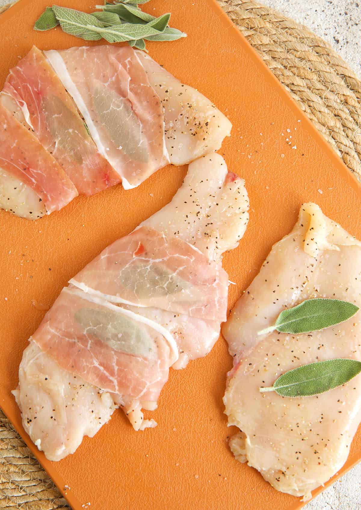 Sage leaves and prosciutto added to chicken cutlets before cooking