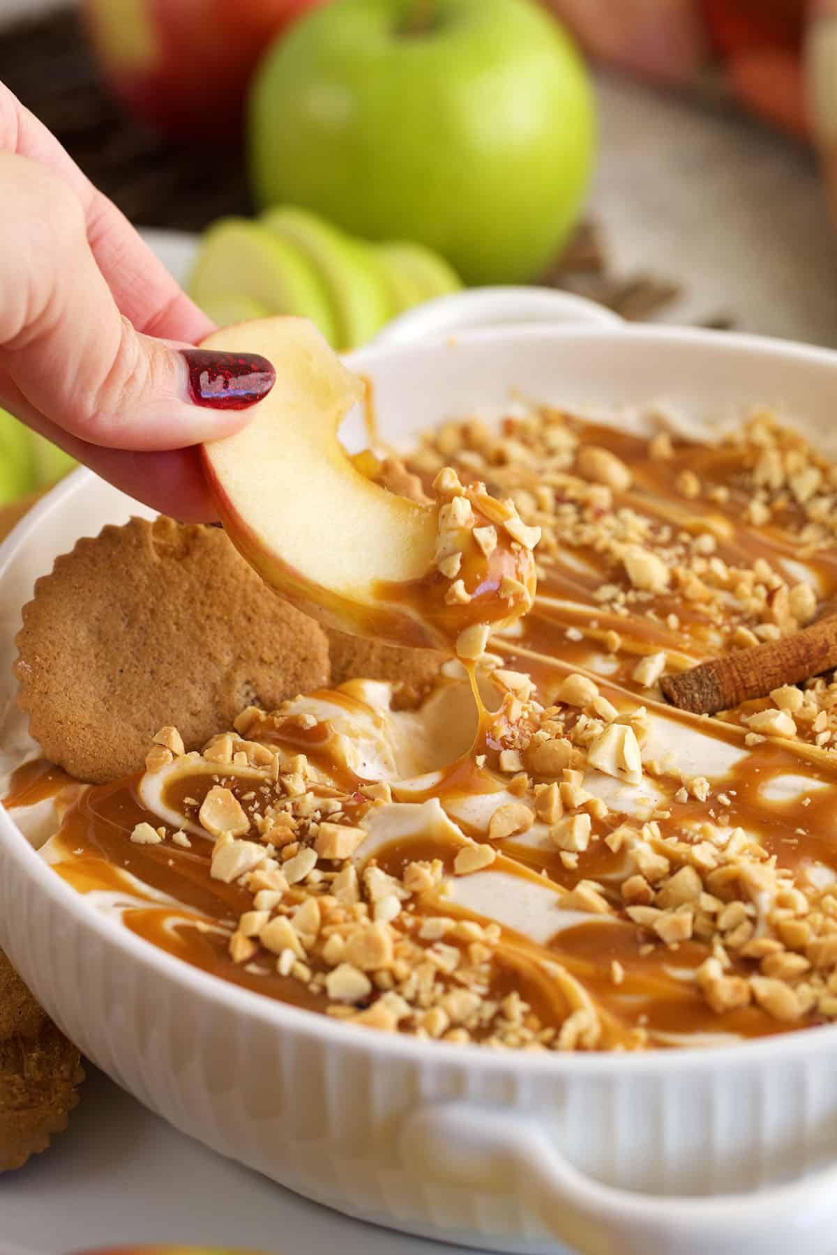 Dipping apple into caramel apple dip