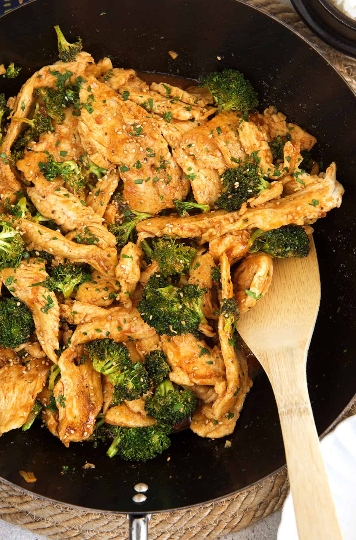 Stirring chicken and broccoli stir fry in skillet