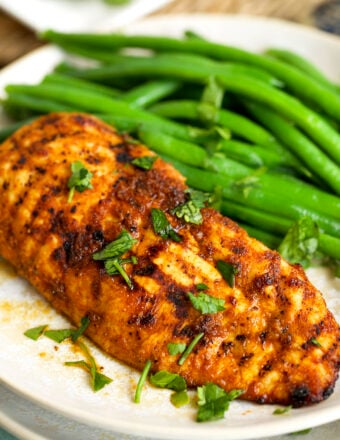 Air fryer chicken breast on plate with green beans