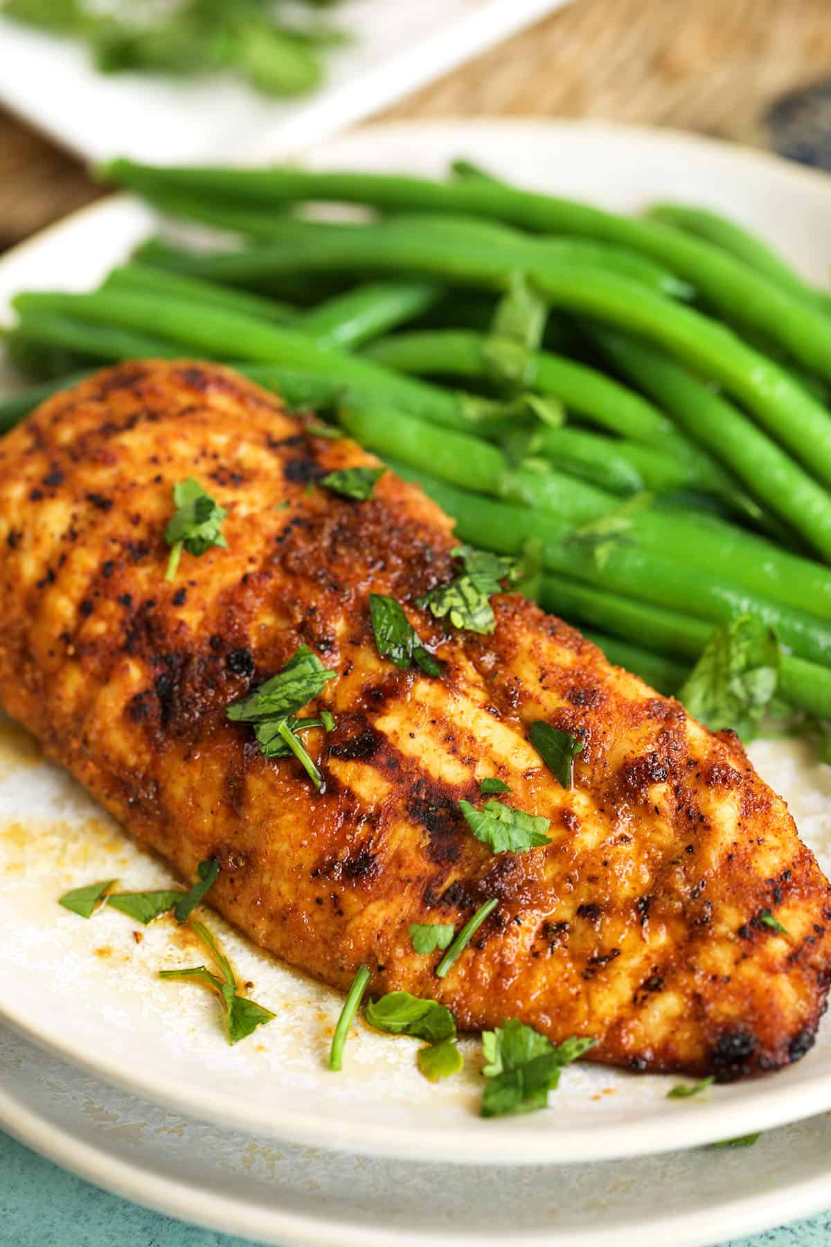 Air fryer chicken breast on plate with green beans