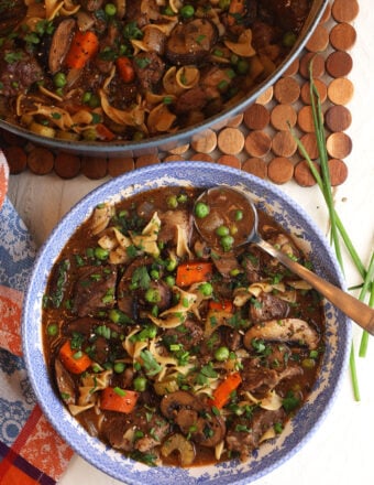 Overhead view of beef noodle soup in pot and bowl