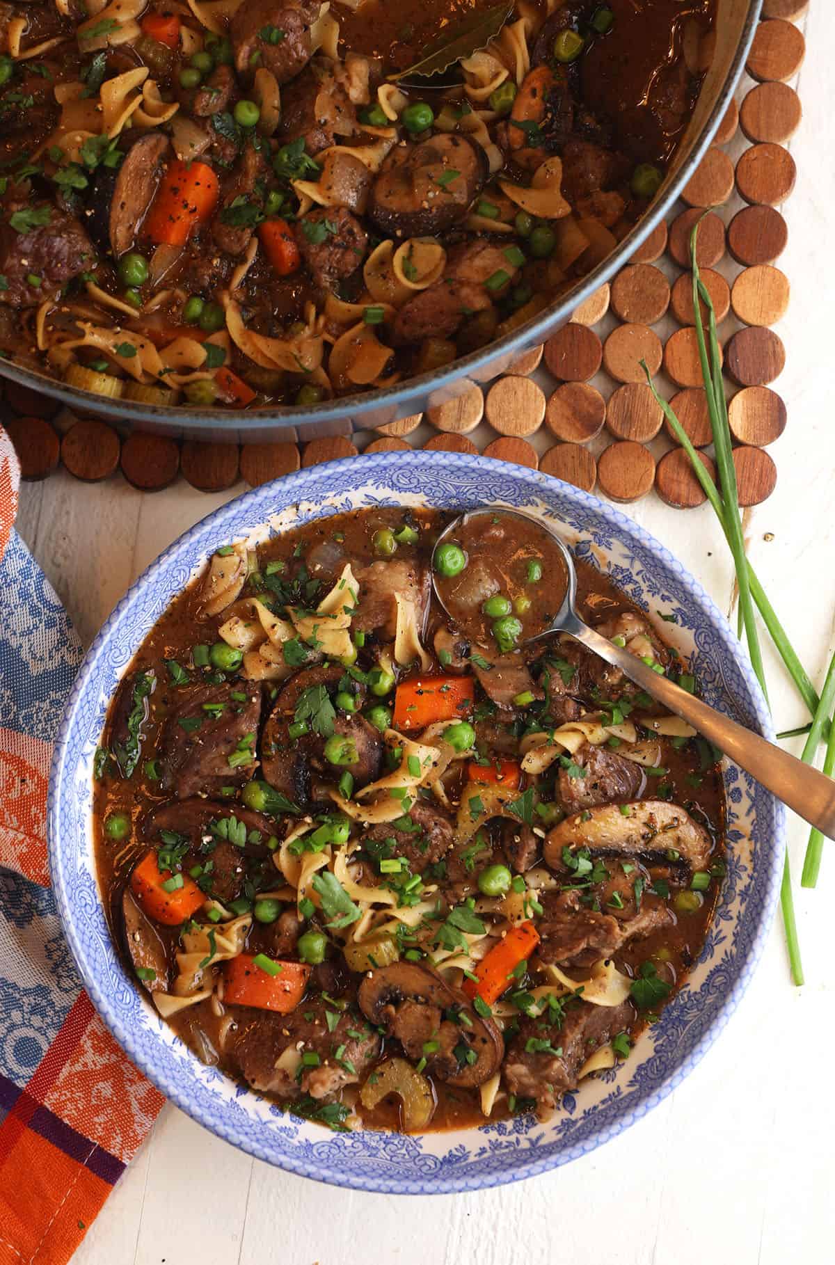 Overhead view of beef noodle soup in pot and bowl