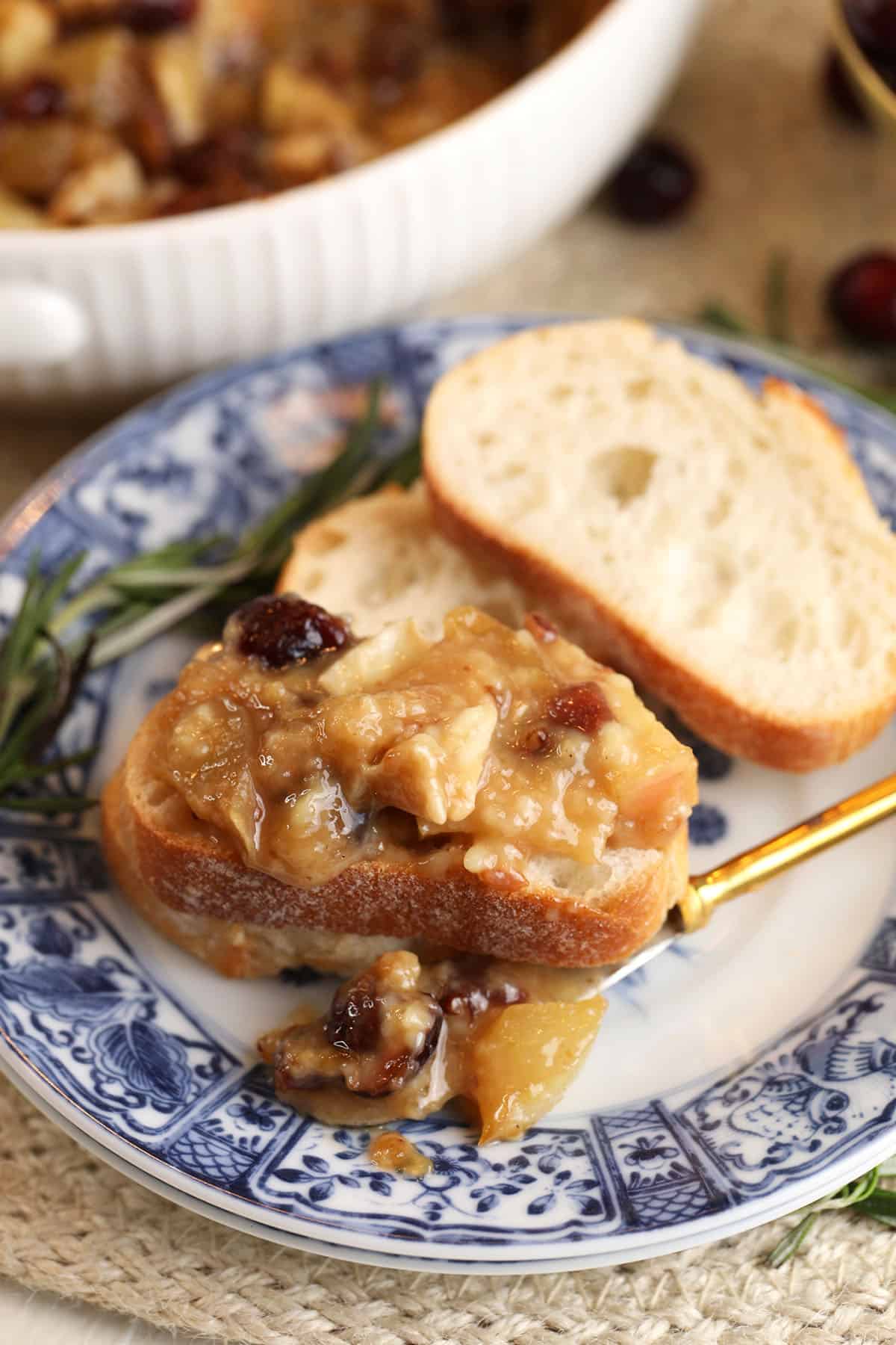 Brown sugar baked brie dip on plate with crostini