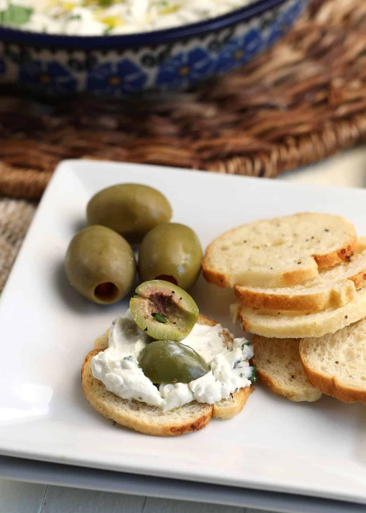 Dirty martini dip on crostini with olives