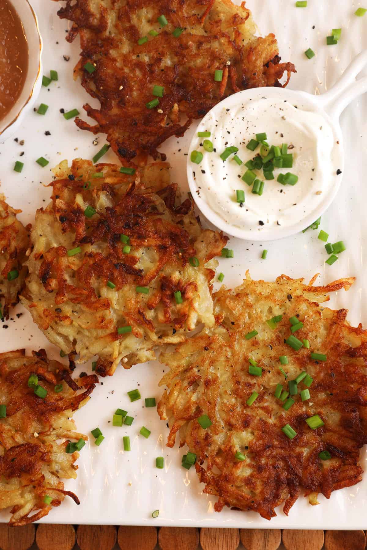 Overhead view of Polish potato pancakes with bowl of sour cream