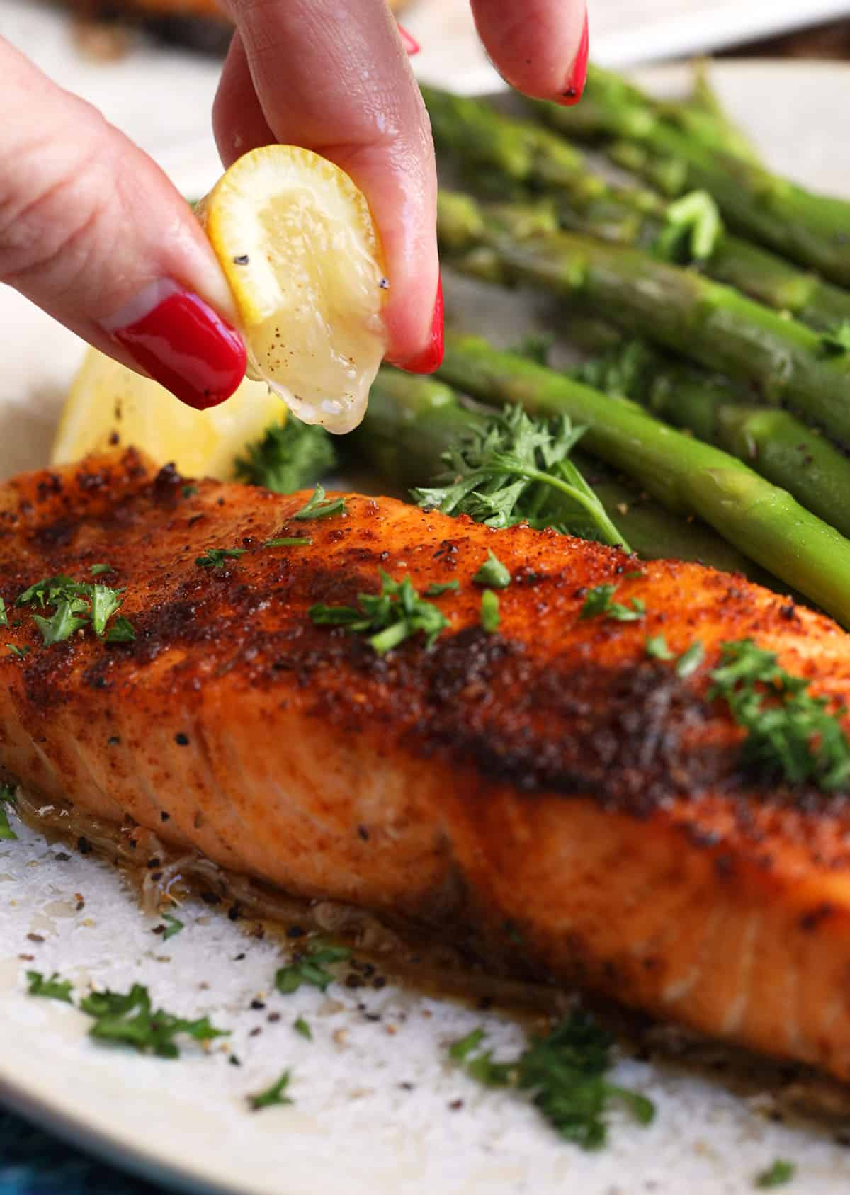 Squeezing lemon onto air fryer salmon