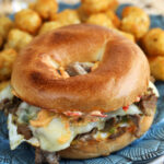 Philly cheesesteak breakfast bagel sandwich on plate