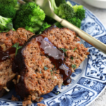 Slices of air fryer meatloaf on plate with broccoli
