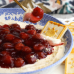 Bowl of cherry cheesecake dip with shortbread cookie