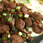 Garlic butter steak bites garnished with green onion