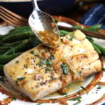 Drizzling miso garlic butter sauce onto mahi mahi fillet