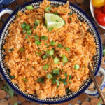 Overhead view of Spanish rice in serving bowl with lime wedge