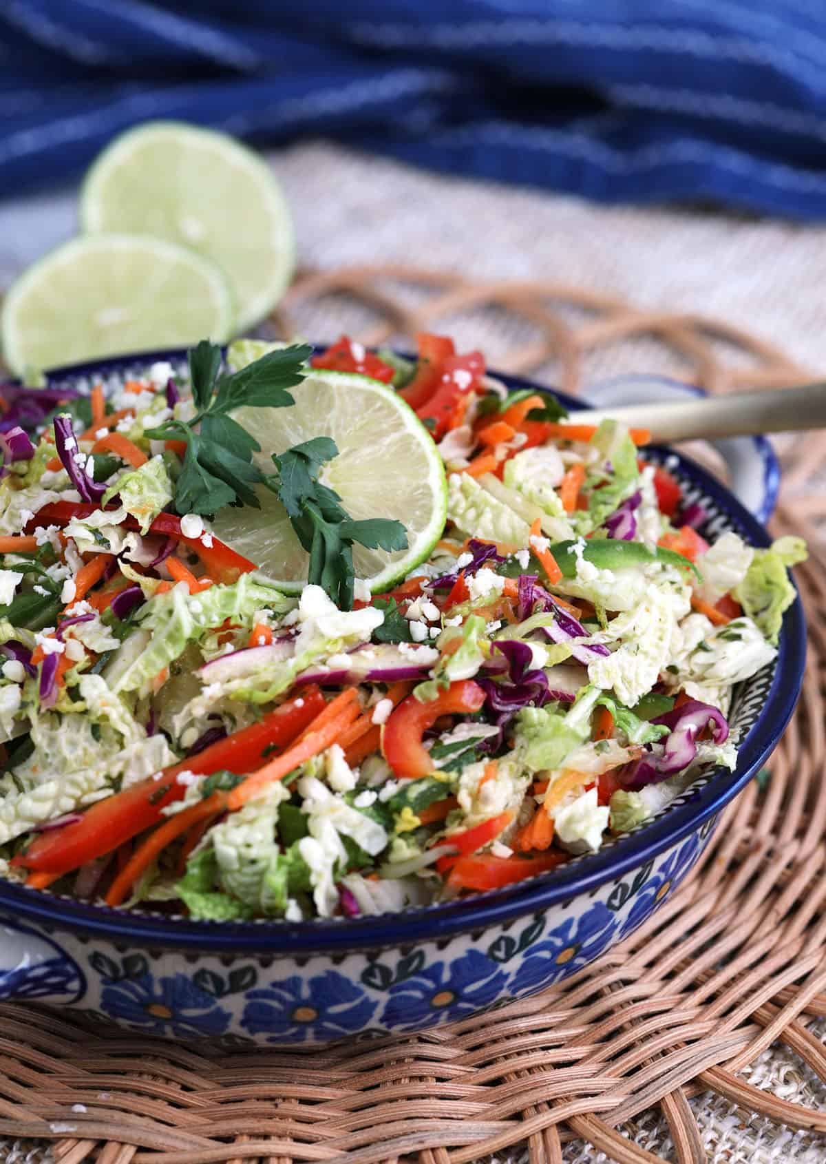 Bowl of Mexican coleslaw with sliced lime for garnish