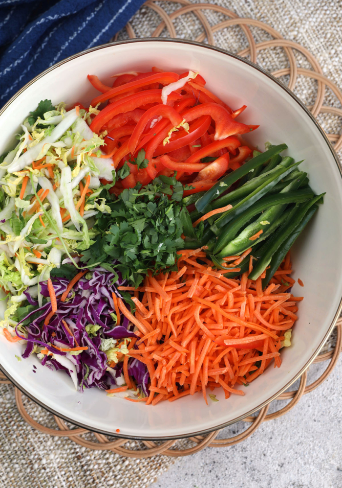 Overhead view of ingredients for Mexican coleslaw in bowl before tossing