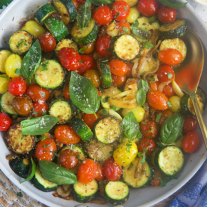 Sautéed zucchini in a skillet with a gold handle.