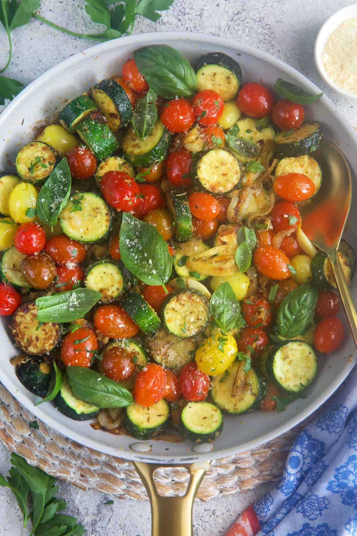 Sautéed zucchini in a skillet with a gold handle.