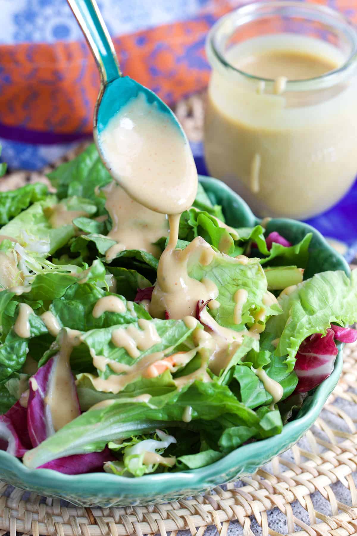 salad with tahini salad dressing being drizzled on top