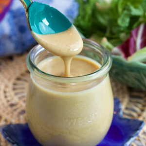 Tahini Salad dressing in a jar with a teal spoon