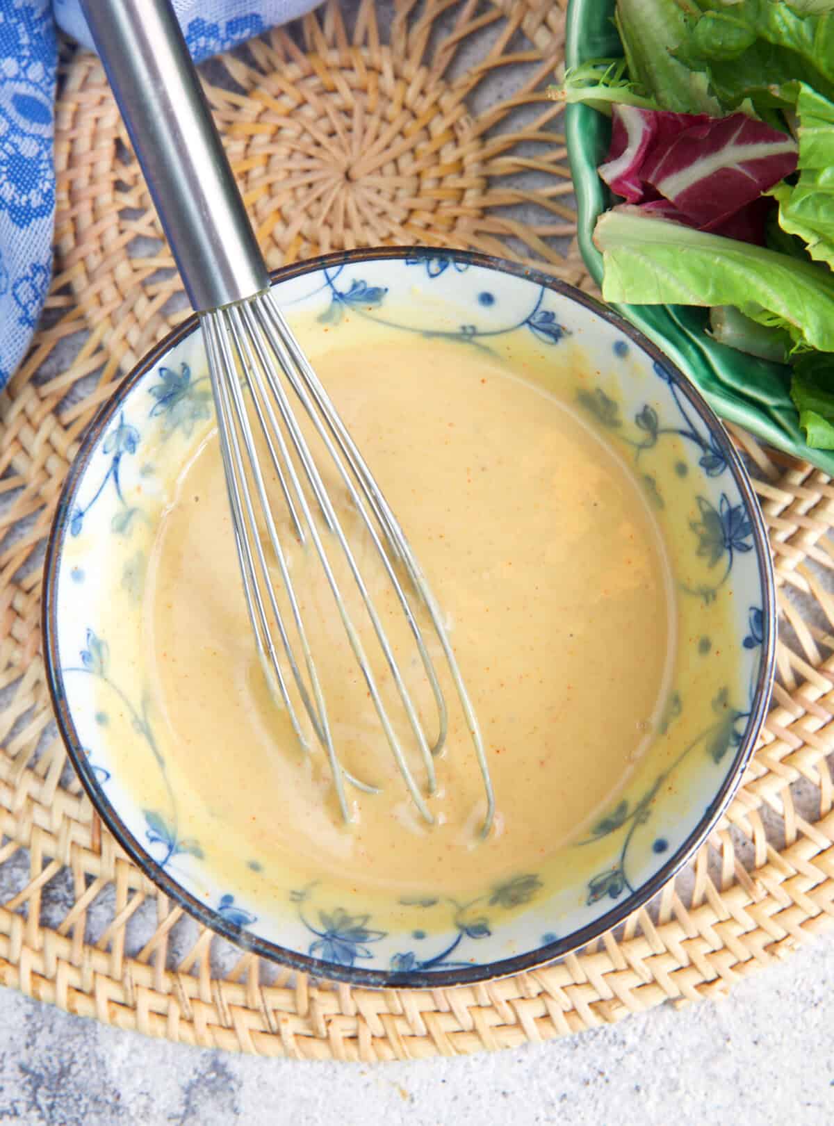 Tahini dressing being whisked in a bowl