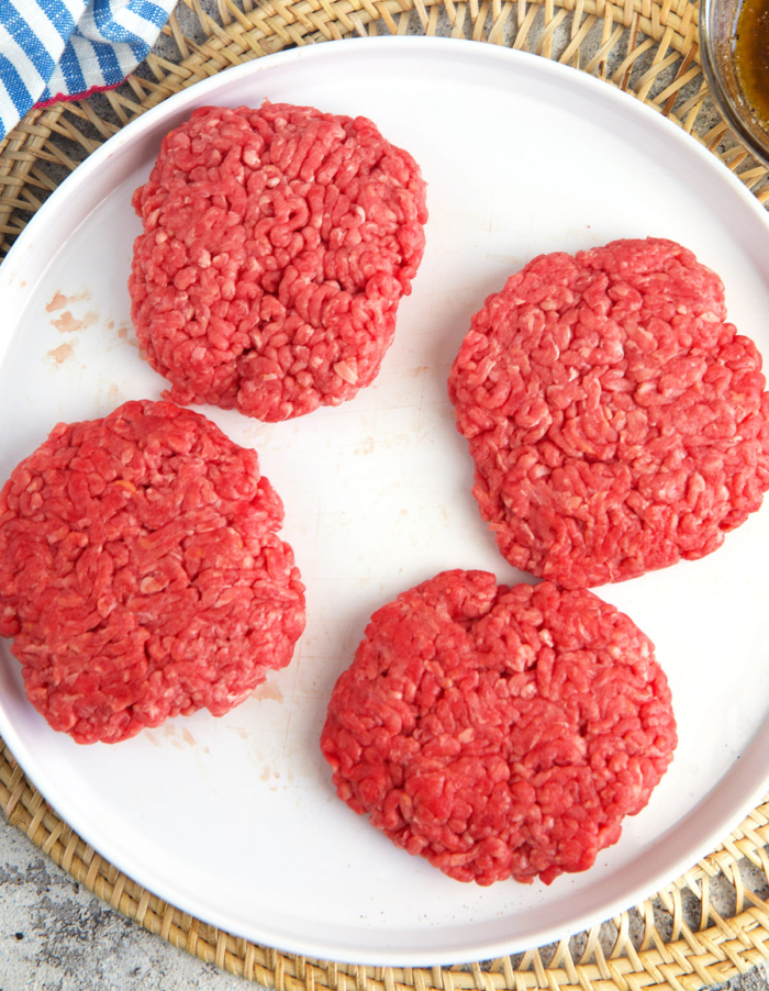 ground beef formed into burger patties on a white plate