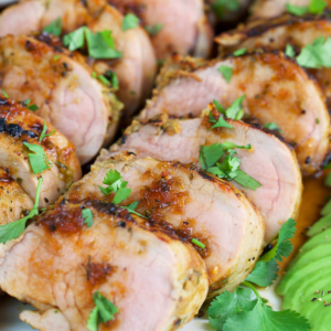 Sliced jerk pork on a white platter.