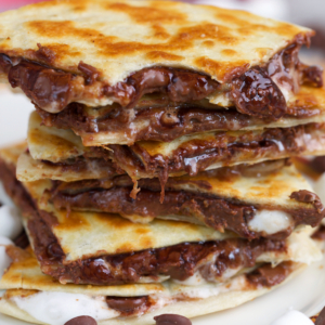 S'mores Quesadillas stacked with a bite out of the top slice.