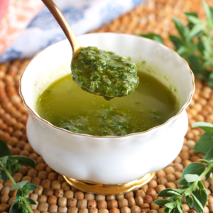 Spoonful of chimichurri sauce over a bowl.