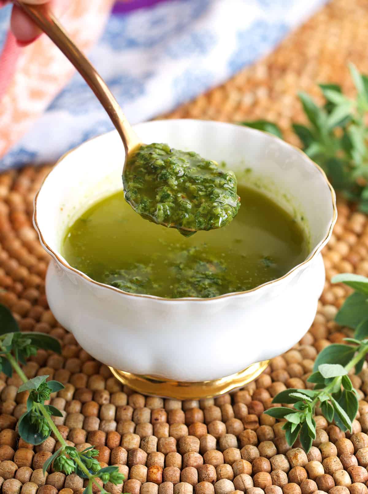 Spoonful of chimichurri sauce over a bowl.