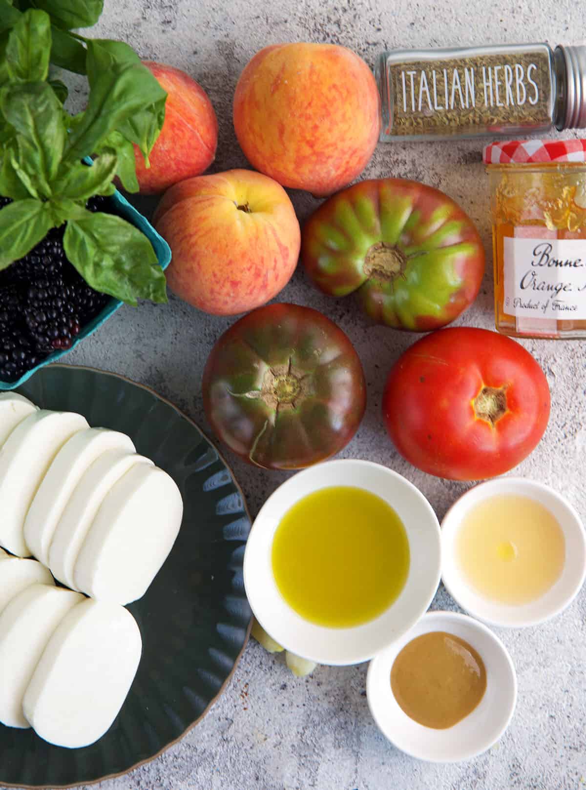 Ingredients for Peach Caprese Salad on a gray background.