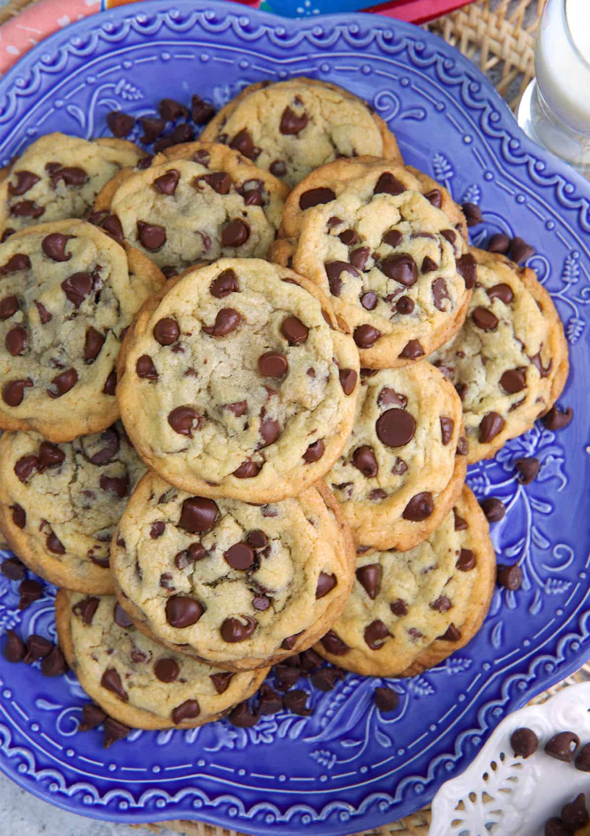 Chocolate chip cookies stacked on a blue serving platter.