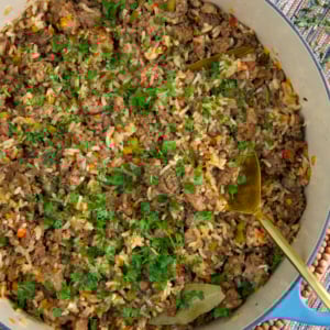 Cajun Dirty Rice in a dutch oven with a gold serving spoon